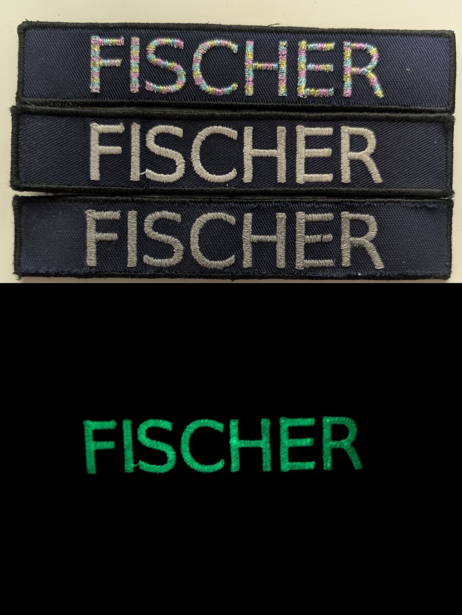 Klettnamensschilder, von oben nach unten: buntes Metallic-Garn, Nachtleuchtgarn, reflektierendes Garn. Obere Bildhälfte bei Licht, untere im Dunkeln. Im Dunkeln ist nur das Schild mit Nachtleuchtgarn sichtbar, welches allerdings zuvor stark mit einer Taschenlampe beleuchtet wurde. Andernfalls würde es nicht so hell leuchten.